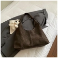 Detail der dunkelbraunen Hobo-Tasche mit Kontrastnähten und Plüschbär-Anhänger auf Anzug - Kaffee Mit Anhänger