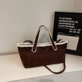 Detail van bruine suède handtas met witte imitatiebont rand en verstelbare riem - koffiekleur