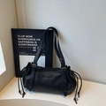 Detailed view of black lychee grain leather tote with side drawstrings and metal plaque - Black