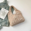 Detail of oatmeal knit handbag with elegant pearl bow accents and soft woven texture - Khaki