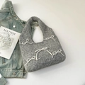 Close-up of grey wool handbag featuring elegant white faux pearl bow tie ornaments - Gray