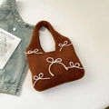 Detailed shot of a brown felt tote bag with white pearl bow accents and soft knit texture - Brown