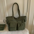 Detailed view of army green corduroy tote bag with large front pockets and zip closure - Green
