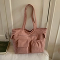 Detail view of pink corduroy tote bag showing front flap pocket and drawstring pouch - Pink