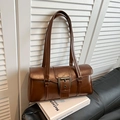 Close-up of brown PU leather shoulder bag with metallic buckle and glossy finish - Brown