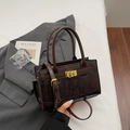 Détail du sac à main marron foncé motif crocodile avec fermoir doré et bandoulière - café
