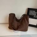 Détail de la texture en daim marron foncé et des coutures de ce grand sac cabas chic - Marron