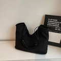 Vue détaillée du grand sac cabas en daim noir posé sur une surface en marbre blanc - Noir