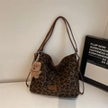 Close-up of leopard print tote bag with brown leather label and plush bear keychain - With Pendant / Green