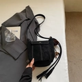 Dettaglio della borsa a secchiello nera opaca con cuciture bianche e nappe decorative - Nero Con Pendente