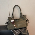 Dettaglio della borsa tote verde oliva con cuciture a contrasto e ciondolo a pompon - Con Ciondolo / Verde