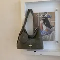 Dettaglio macro della borsa tote verde scuro con cuciture bianche e mini astuccio con zip - Verde