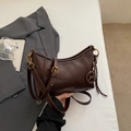 Detalle del bolso de axila en cuero marrón brillante con hebilla dorada y correa fina - Café Con Amuletos