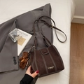 Vue détaillée d'un sac seau marron foncé avec surpiqûres et charm d'ours en peluche - Avec Pendentif / Marron
