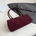 Detalle de bolso de hombro burdeos en ante sintético con textura suave y costuras finas - Rojo