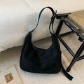 Primer plano detallado de un bolso hobo de ante negro con correa ajustable sobre fondo blanco - Negro