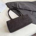 Detalle de textura de cuero retro en un bolso de hombro minimalista marrón oscuro - Gris