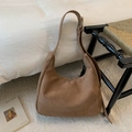 Détail d'un sac hobo en daim marron avec large bandoulière et finition mate et douce - Kaki