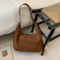 Détail d'un sac hobo en daim marron avec boucle argentée réglable sur un tapis élégant clair - Marron