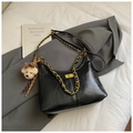 Detail of black leather dumpling bag featuring gold chain strap and teddy bear charm - Black Large With Pendant
