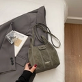 Sac seau gris avec surpiqûres contrastées et bandoulière sur fond de blazer gris chic - Sans pendentif / Vert