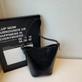 Detailed view of black oil-wax leather bucket bag bottom with embossed logo and gold hardware - Black