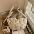 Detail einer cremefarbenen gesteppten Puffer-Hobo-Tasche mit Schleife und winterlichem Flair - Cremeweiß