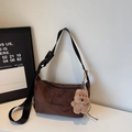 Detalle del bolso tote de ante marrón con bordado Banana & bag y un dije de oso de peluche - Café Con Amuletos