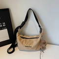 Detalle de bolso hobo de ante beige con logo negro y colgante de perrito de peluche marrón - Caqui Con Colgante