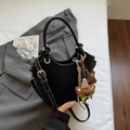 Detail of black matte handbag with contrast stitching and plush bear charm accessory - With Pendant / Black
