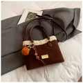 Brown faux suede bucket bag with cream shearling trim and plush orange charm accessory - With Pendant / Brown
