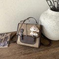 Detail view of khaki canvas and brown leather backpack with cute dog plush keychain and bow - Brown with Pendant