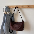 Dark coffee suede tote bag with embroidery and adjustable strap on a coat rack - Coffee No Charm