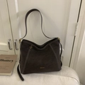Vue détaillée du sac Hobo en daim marron foncé avec surpiqûres blanches et logo - Café sans Pendentif