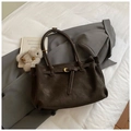 Detail van de donkerbruine retro tote bag met gespband op een grijze blazer - Met Hanger / Bruin
