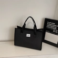 Detalle del bolso tote grande de lona a cuadros con asas tejidas y etiqueta de marca - Negro
