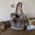 Detailaufnahme der flauschigen Tasche mit Ethno-Muster, Lammwolltextur und Lederlabel - Braun