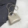 Detailweergave van de crème krokodillenreliëftextuur op een chique handtas - Broken Wit
