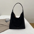 Detail of black suede leather tote bag showing white printed text and soft texture - Black
