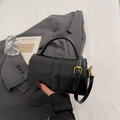 Dettaglio della borsa in pelle nera con goffratura verticale e fibbia in metallo dorato - Nero