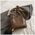 Dark brown faux leather bucket bag with metallic rivets and trendy woven shoulder strap - Tan