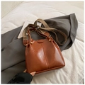 Vintage brown bucket bag featuring stylish wide woven strap and polished gold hardware - Brown
