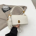 Detalle del bolso de cuero blanco crema con cierre giratorio de metal dorado vintage - Blanco