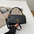 Detalle de bolso de cuero negro con hebilla metálica dorada y correa ajustable - Negro