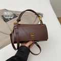 Detalle del bolso de cuero marrón suave con asa de nudo y cierre dorado en forma de C - Marrón