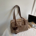 Details einer braunen Wildleder-Schultertasche mit Bärenanhänger und Ledergriffen - Khaki Mit Anhänger