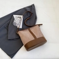 Detailopname van de bruine emmertas met mat suède en gladde lederen texturen combi - Khaki