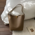 Détail d'un sac seau en cuir marron avec boucle en métal doré et logo de marque gravé - Sans Pendentif / Marron