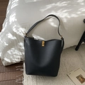 Détail du sac seau en cuir grainé noir avec fermoir rotatif doré et texture raffinée - Sans Pendentif / Noir