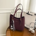 Close-up of the vintage purple tote bag with golden logo and schnauzer leather charm - Wine Red With Pendant